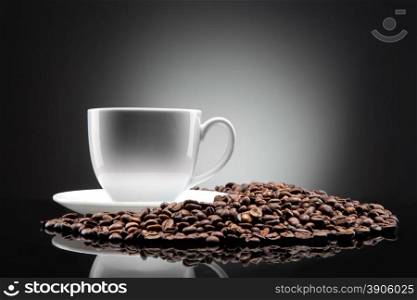 white cup with coffee beans on black