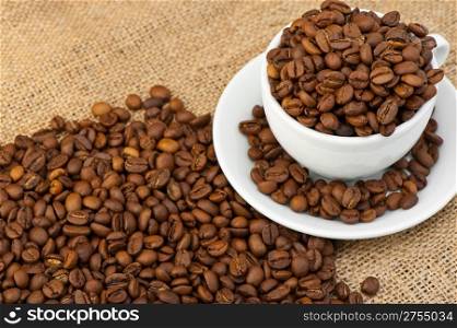 White cup with coffee grains. Grunge background