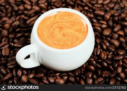 White cup with espresso coffee and coffee beans, flat lay. close-up. Morning strong Italian coffee with fragrant foam, top view. Coffee idea for breakfast