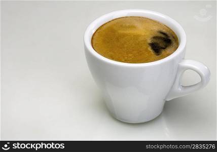 White cup with espresso coffee on the abstract reflected background