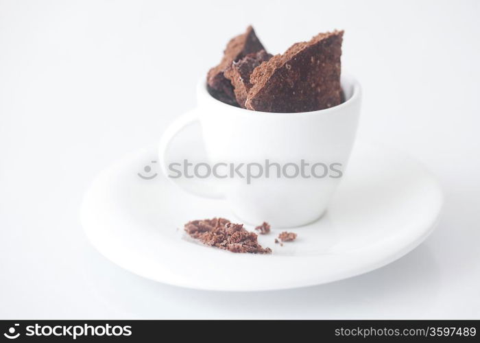 white cup with saucer and chocolate