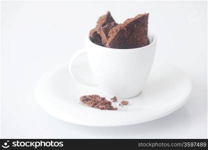 white cup with saucer and chocolate