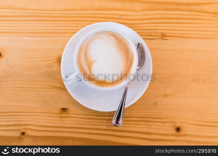 white cupof capuccino on wooden table