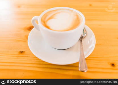 white cupof capuccino on wooden table