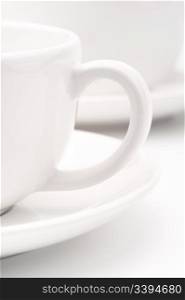 White cups. A pair of white tea cups on a white background, selective focus, simple dishware abstract, cafe concept
