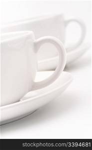 White cups. A pair of white tea cups on a white background, selective focus, simple dishware abstract, cafe concept