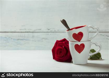 White Cups and roses on a Wooden Background. Love or Valentine&rsquo;s Day Concept.