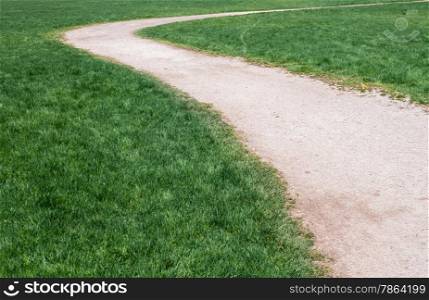 White curving gravel path on green grass.