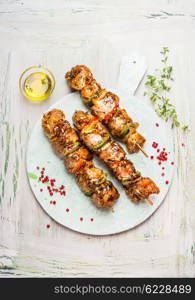 White cutting board with tasty Meat skewers on light rustic background, top view