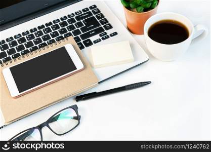 White desk office with laptop, smartphone and other work supplies with cup of coffee. close up ,copy space.