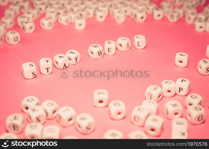 White dices over a pink pastel background with stay well message, wellness and life concepts