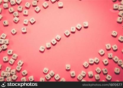 White dices over a pink pastel background with stay well message, wellness and life concepts