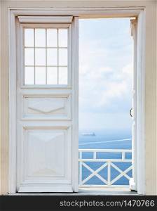 white door opening to blue sea