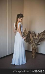 White dress with open back.. A beautiful girl in open dress with long brown hair oblique 4935.