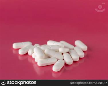 White drugs pillows scattered on a red background. White pills pillows scattered on a red background
