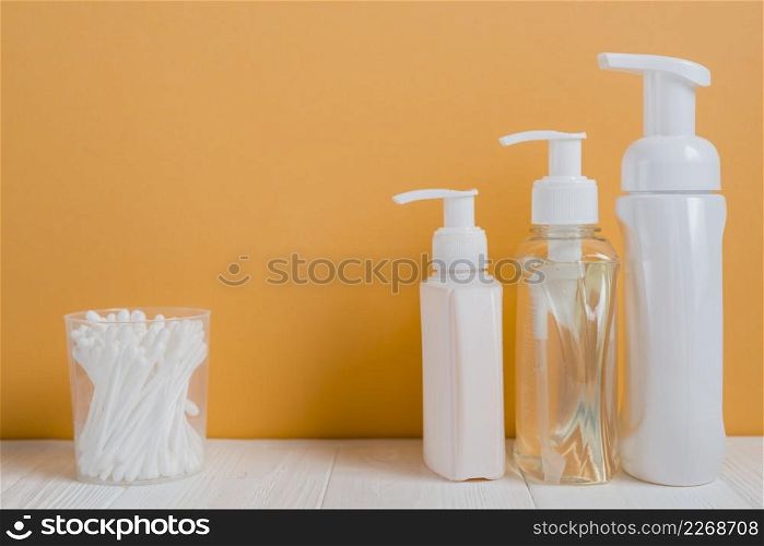 white ear buds with soap dispenser bottles white table