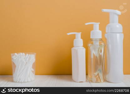 white ear buds with soap dispenser bottles white table