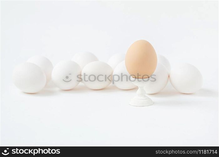 White eggs on wooden coasters forms white background. Getting ready for the Easter holiday. One leader among all.. White eggs on wooden coasters forms white background. Getting ready for the Easter holiday.