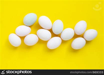 White eggs on yellow background. Top view