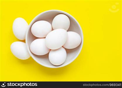 White eggs on yellow background. Top view