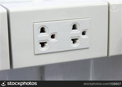 White electric plugs on wall background.