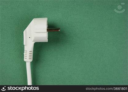 white electrical cable with plug on the green background