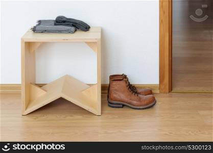 White empty anteroom with wooden stool and leather boots
