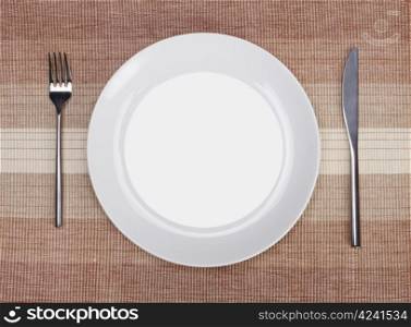 White empty plate with fork and knife