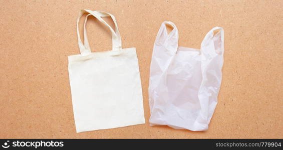 White fabric bag with white plastic bag on plywood background. Copy space
