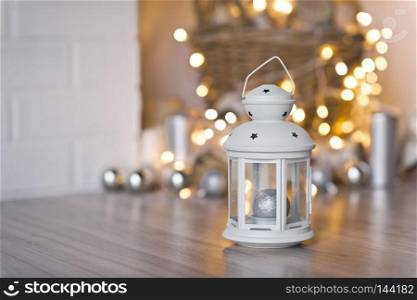 White flashlight on a background of twinkling lights.. Lantern for candle in the background of the Boke from the lights of garlan
