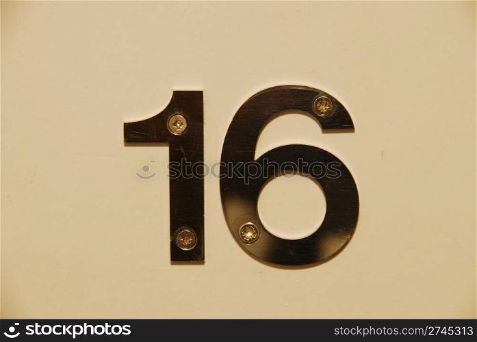 white flat metallic number hanging on the door