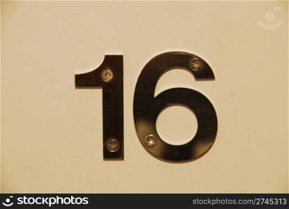 white flat metallic number hanging on the door