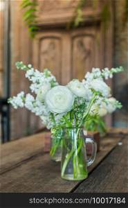 White flowers in a vintage style glass vase.