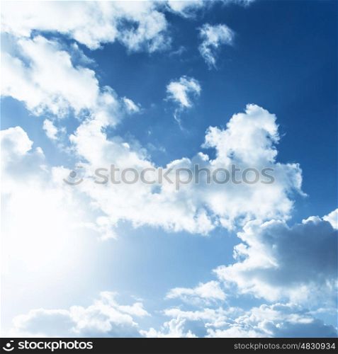 White fluffy clouds on blue sky, bright sun light, abstract natural background, summer season, meteorology concept&#xA;