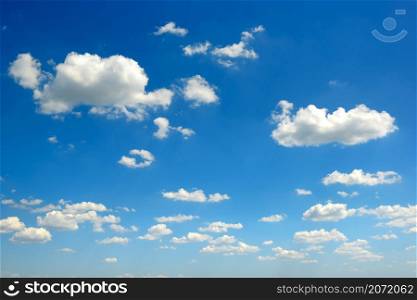 White fluffy clouds on bright blue sky background.