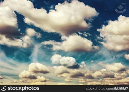 White fluffy clouds on the blue sky. Nature background, colorized like instagram