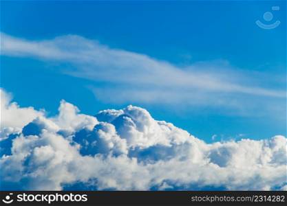 White fluffy cumulus clouds against a clear blue sky. Top view from the plane. Background for design.. White fluffy cumulus clouds against a blue sky. Top view from the plane. Background for design.