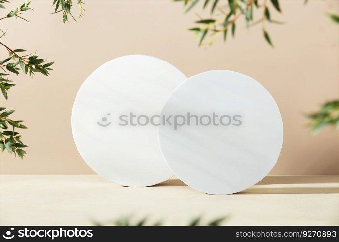 White foam circle shaped pedestals and eucalyptus branches on beige table with copy space, side view. Podium mockup background for products. Advertising template. Foam platform. Abstract geometric pedestal.