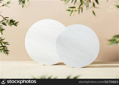 White foam circle shaped pedestals and eucalyptus branches on beige table with copy space, side view. Podium mockup background for products. Advertising template. Foam platform. Abstract geometric pedestal.