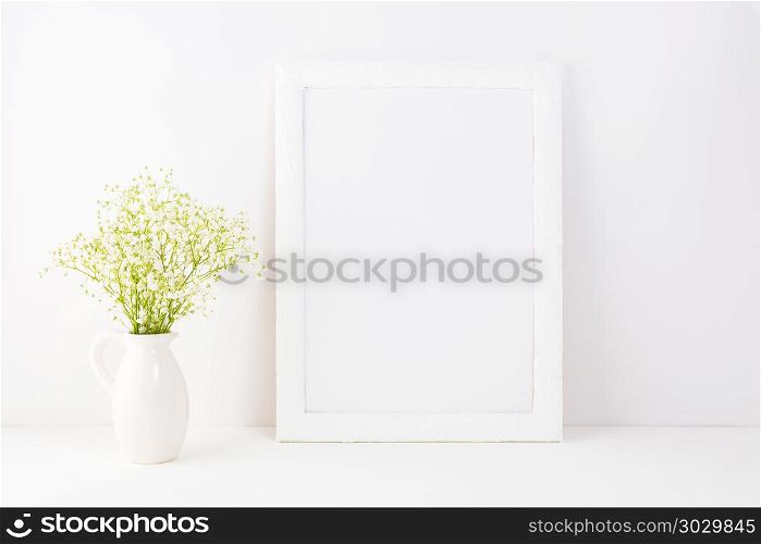 White frame mockup with baby&rsquo;s breath flowers. White frame mockup with tender elegant baby&rsquo;s breath flowers. Empty frame mock up for presentation artwork. Template framing for modern art.