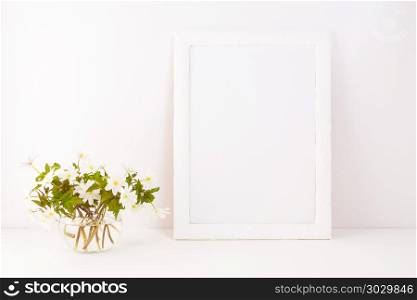 White frame mockup with blooming Rue Anemone. Empty frame mock up for presentation artwork. Template framing for modern art.. White frame mockup with Rue Anemone flowers