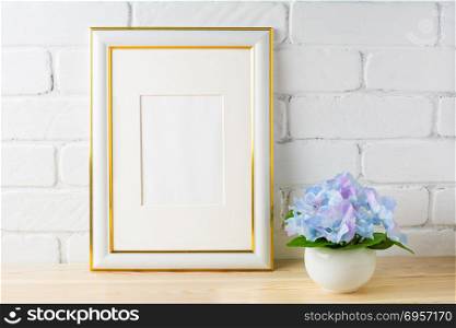White frame mockup with blue hydrangea. White frame mockup with blue hydrangea. Empty white frame mockup for design presentation. Portrait or poster white frame mockup for artwork promotion.