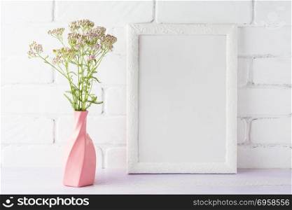 White frame mockup with creamy pink flowers in swirled vase. Empty frame mock up for presentation design.. White frame mockup with creamy pink flowers in swirled vase