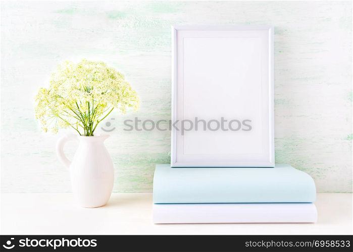 White frame mockup with pale mint book. Empty frame mock up for presentation artwork.. White frame mockup with pale mint book