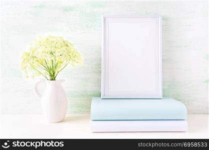 White frame mockup with pale mint book. Empty frame mock up for presentation artwork.. White frame mockup with pale mint book