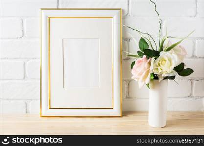 White frame mockup with pale pink roses in vase. White frame mockup with pale pink roses in vase. Portrait or poster white frame mockup. Empty white frame mockup for presentation artwork.