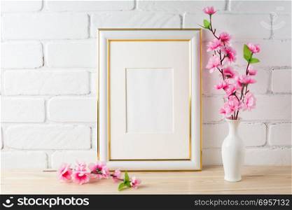 White frame mockup with pink flower bunch. White frame mockup with pink flower bunch. Empty white frame mockup for design presentation. Portrait or poster white frame mockup romantic style.