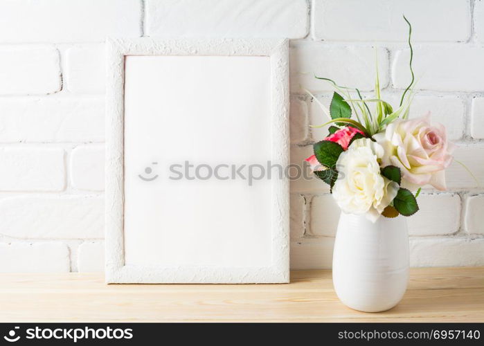 White frame mockup with tender pink roses bunch. Empty white frame mockup for design presentation. Portrait or poster frame mockup.. White frame mockup with tender pink roses bunch