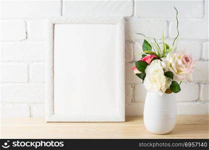 White frame mockup with tender pink roses bunch. Empty white frame mockup for design presentation. Portrait or poster frame mockup.. White frame mockup with tender pink roses bunch