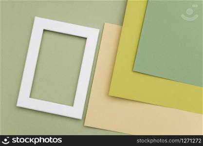 White frame on geometric green shades paper background. Copy space, mockup for your design, text.. White frame on geometric green shades paper background. Copy space, mockup for your design, text
